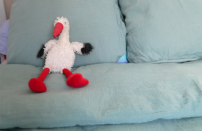 peluche cigogne sur lit